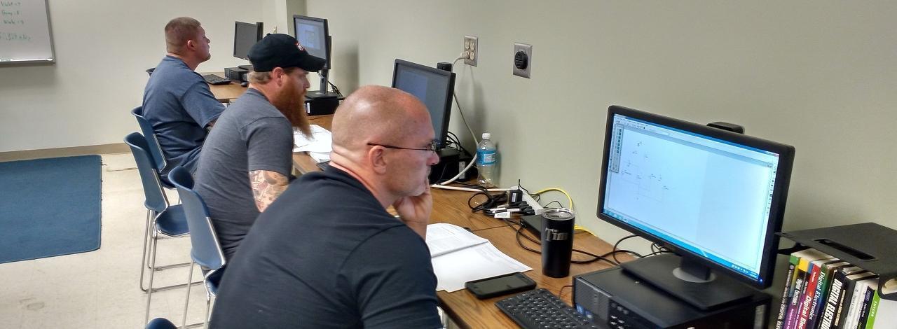 Student studying circuits drawn on a computer screen for the Industrial Electricity program.