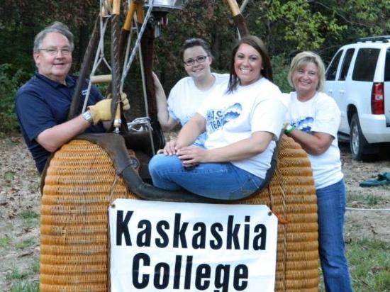 Students smiling, sitting in a basket preparing for a balloon launch.