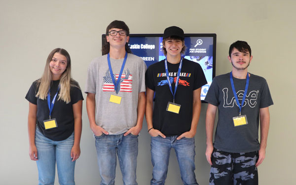 Students standing in front of a wall.